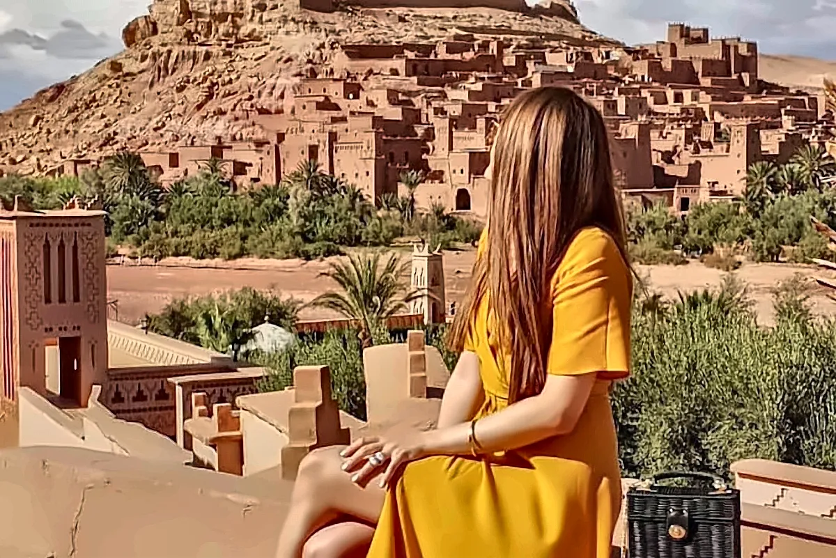 Una visitatrice seduta su una terrazza davanti al ksar di Ait Ben Haddou