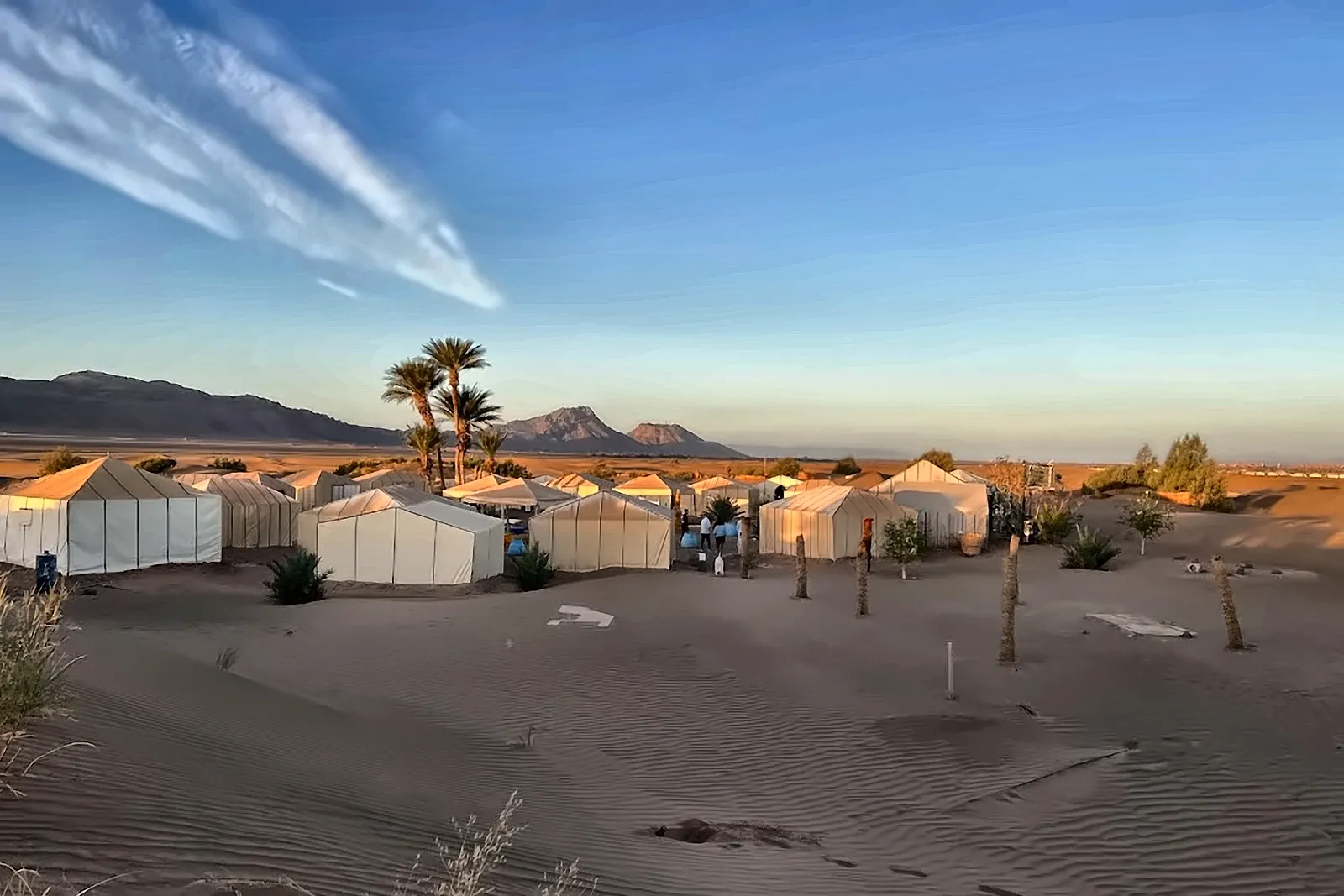 Il campo tendato al crepuscolo, con le dune scure sullo sfondo