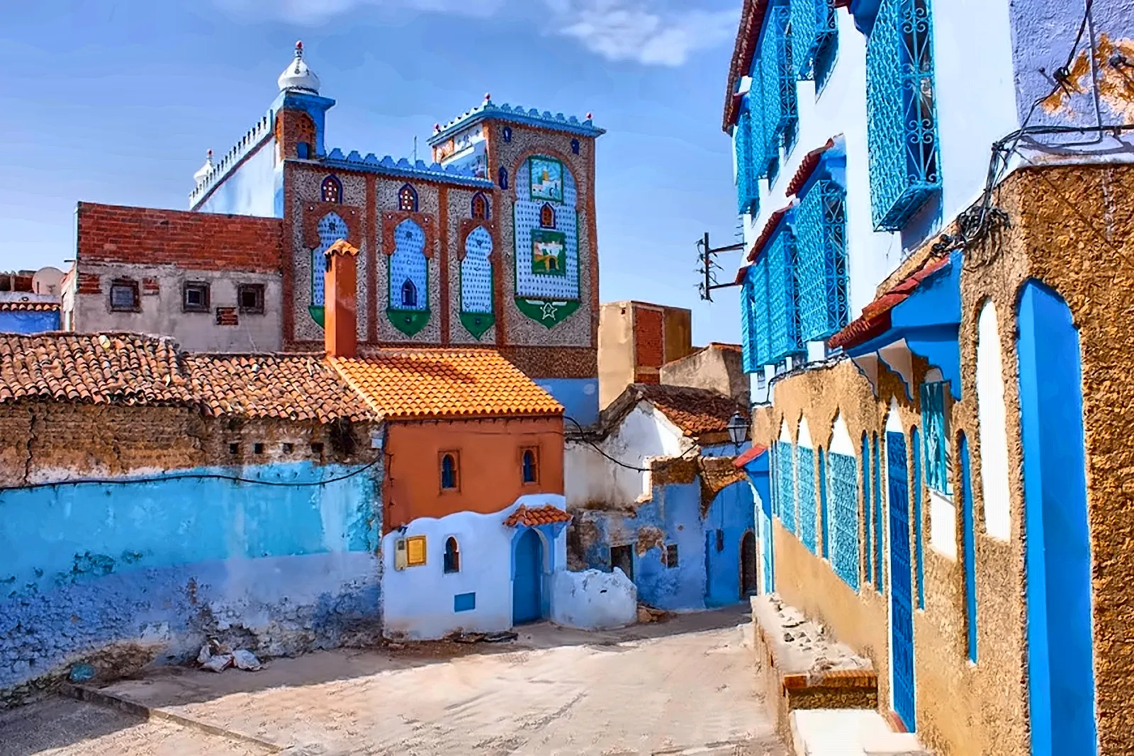 Il minareto e le botteghe lungo un vicolo azzurro di Chefchaouen