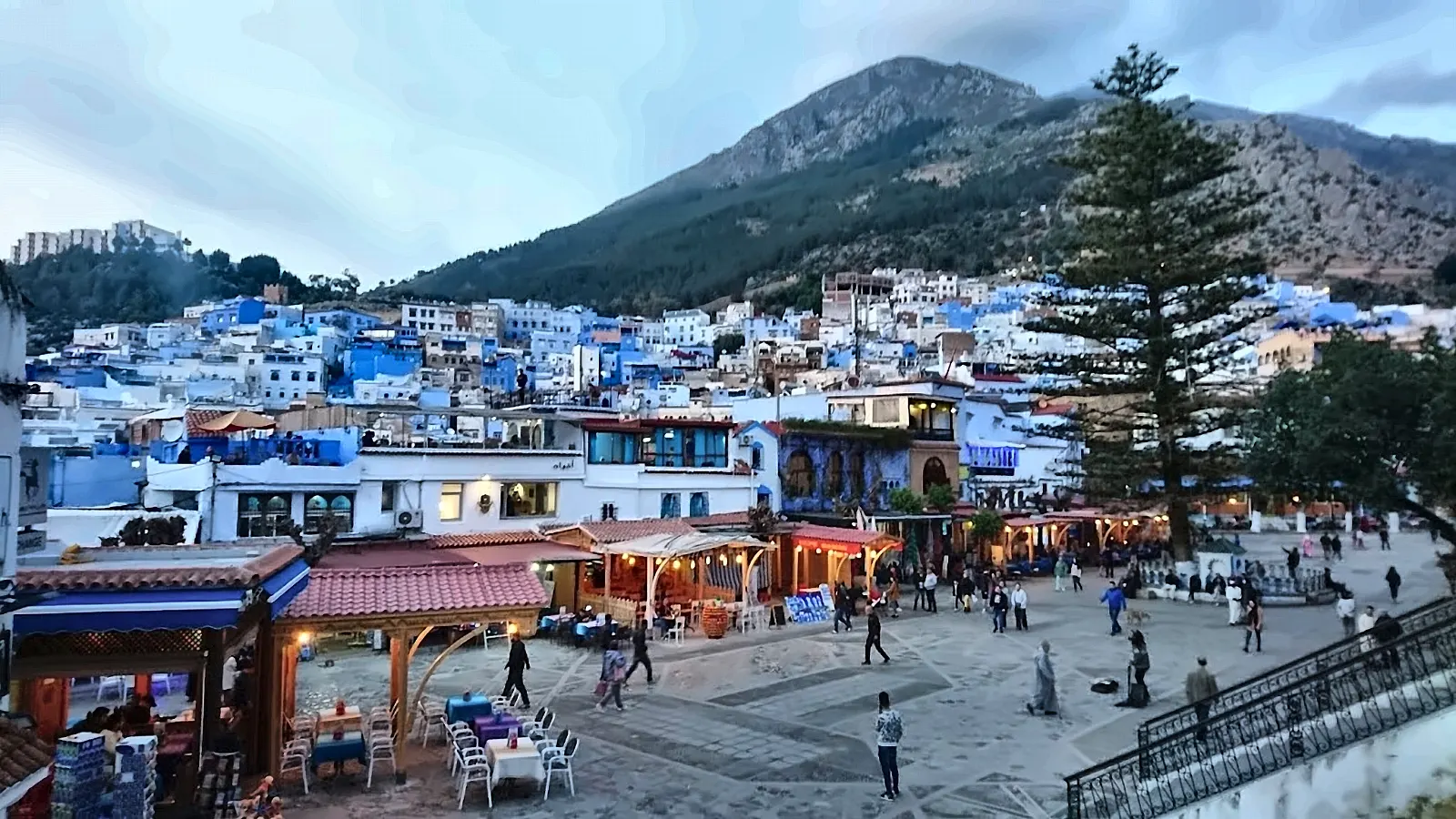 La piazza di Chefchaouen con i caffè e la montagna del Rif alle spalle