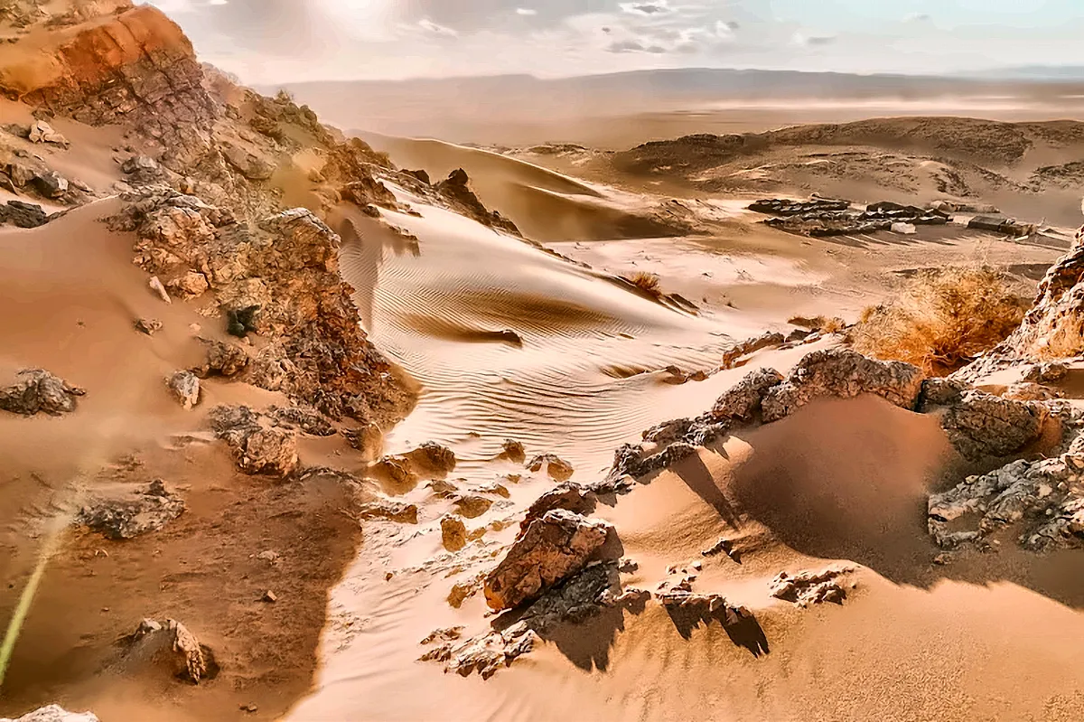 Dune di sabbia e affioramenti di roccia scura nel deserto di Merzouga