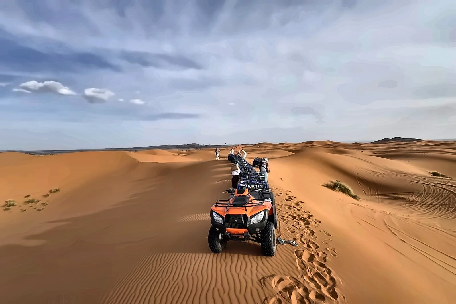 Un quad in mezzo alle dune, con le tracce sulla sabbia